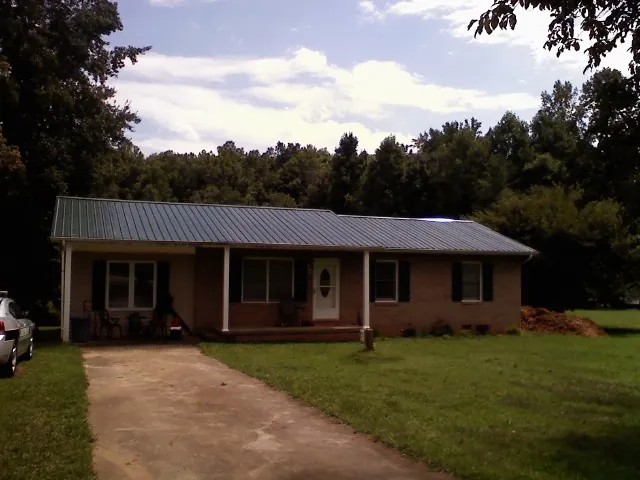 Dark green metal roof on a brick ranch with a covered porch in Indian Wells